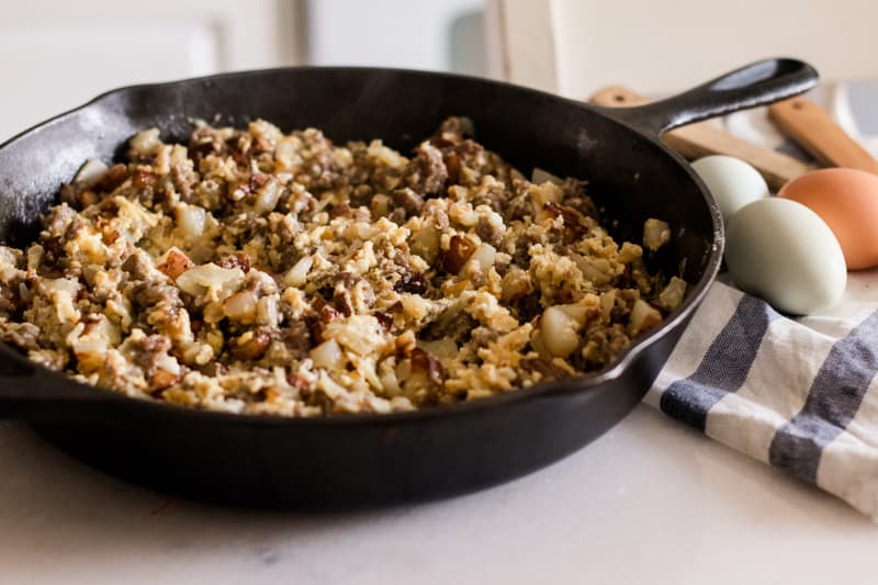 Cast iron skillet with eggs and sausage in it. 