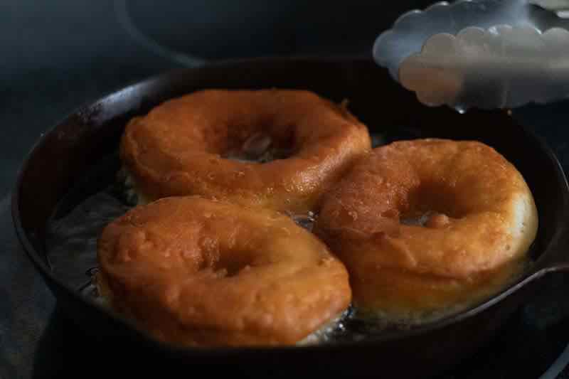 Frying donuts in a cast iron skillet.