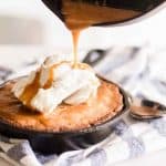 Pouring sauce on top of homemade skillet blondie.
