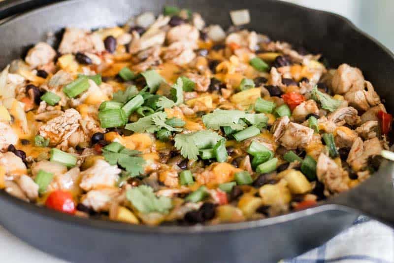 Fiesta chicken and cheese skillet topped with cilantro and green onions.