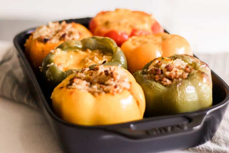 6 stuffed bell peppers in cast iron baking dish.