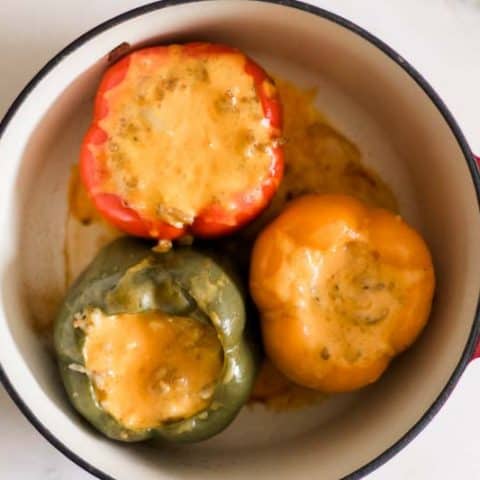 Dutch Oven stuffed peppers topped with cheddar cheese