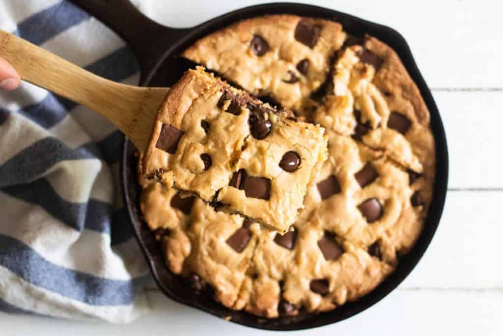 Scooping out a piece of a skillet cookie.