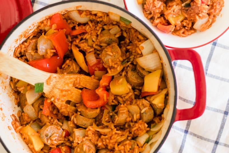 Heaping dish of sausage and peppers with toasted rice.