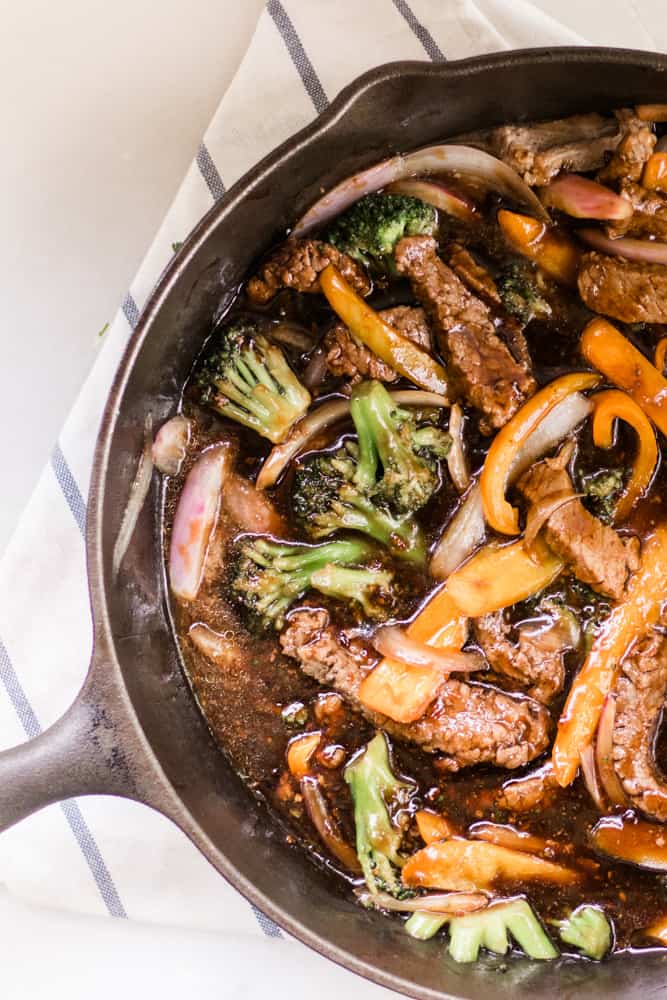 Teriyaki beef and broccoli stir fry in a cast iron skillet.