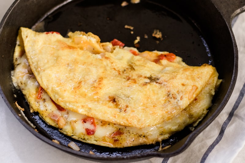 A simple omelette folded in half in a skillet.