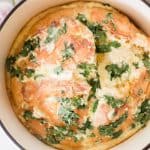 Homemade garlic bread in a dutch oven with fresh parsley sprinkled on top.