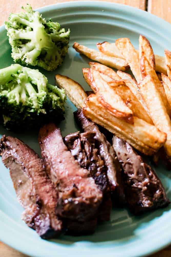 palate of beef steak, broccoli and fries.