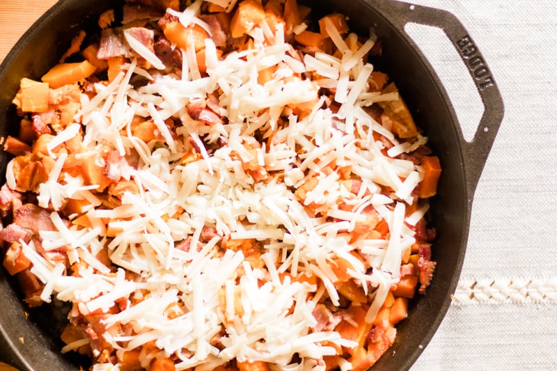 Roasted butternut squash and bacon skillet topped with white cheddar cheese.