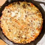 Cast iron breakfast casserole with potatoes, eggs, sausage and vegetables.