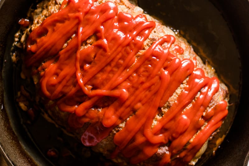 Baked meatloaf in a cast iron skillet.