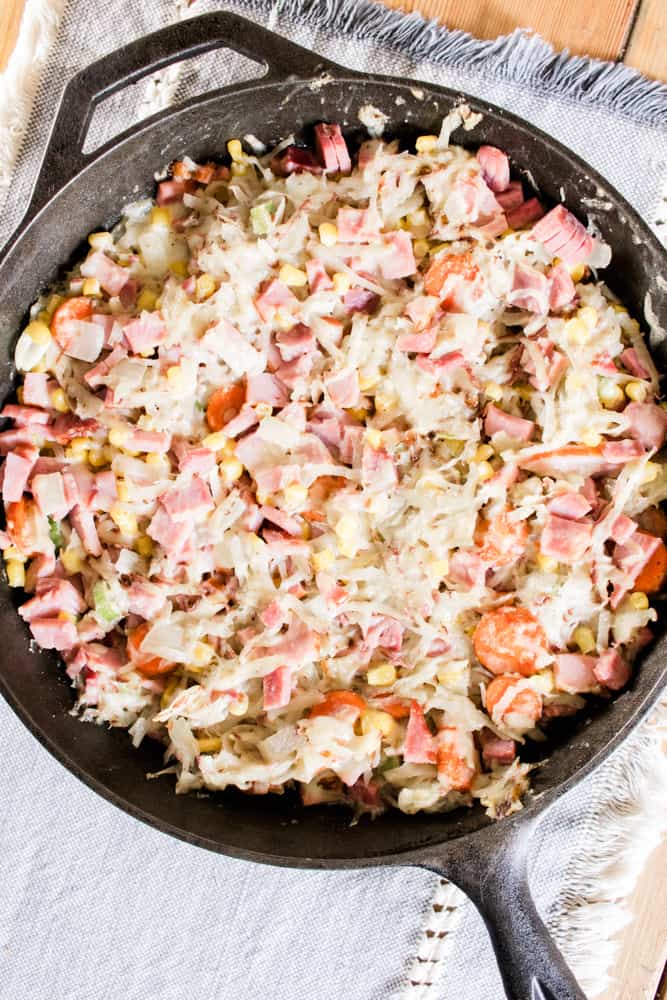 Ham cheese and hashbrowns in a cast iron skillet.