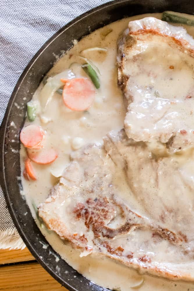 Stovetop smothered pork chops with caramelized onions, green beans and carrots.