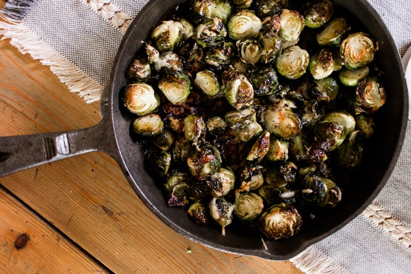 garlic parmesan roasted brussel sprouts in a cast iron skillet.