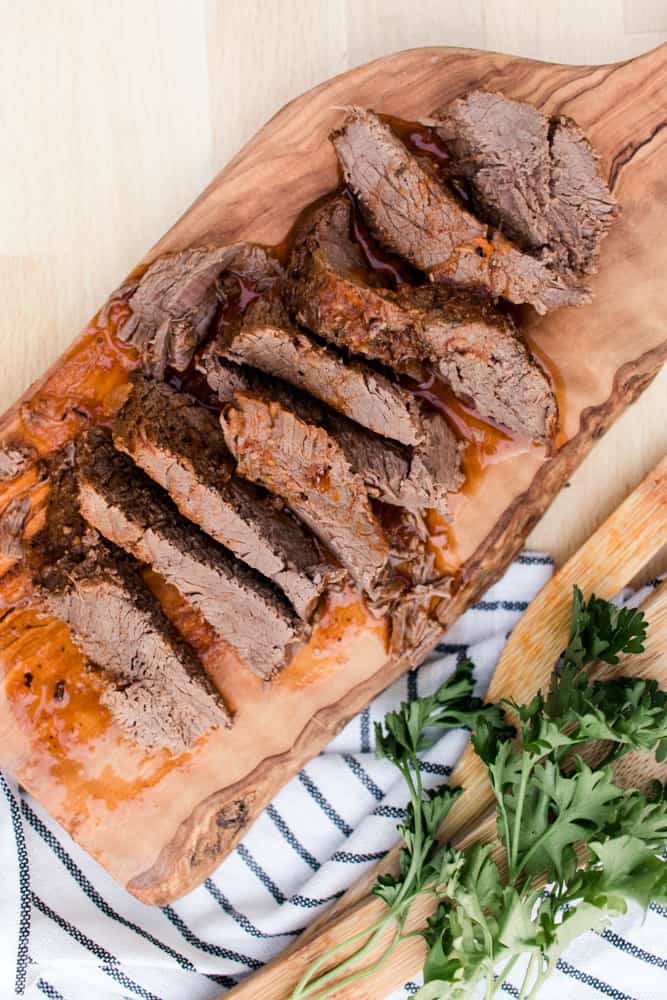 Venison sirloin sliced on a wooden cutting board.