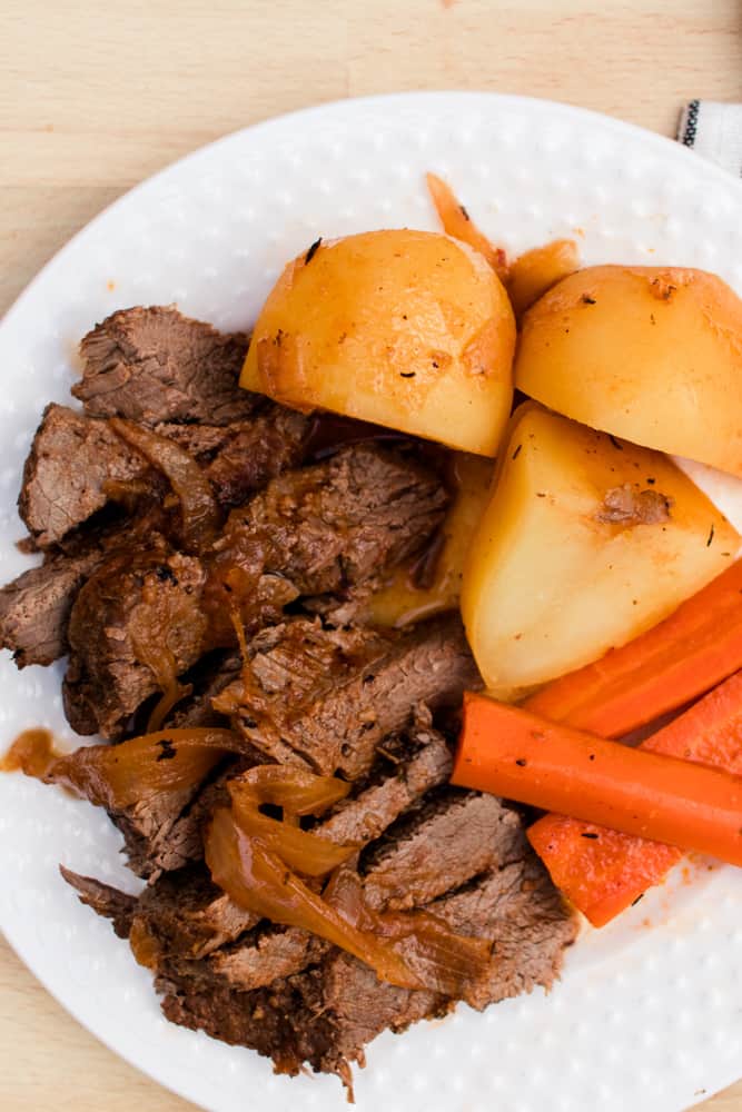 Plate of pot roast with potatoes and carrots.