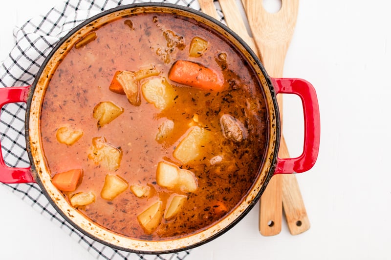 Deer meat stew on white marble table with blue and white tea towel.