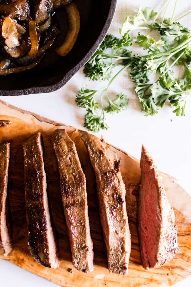 Sliced deer steak with fresh parsley springs.