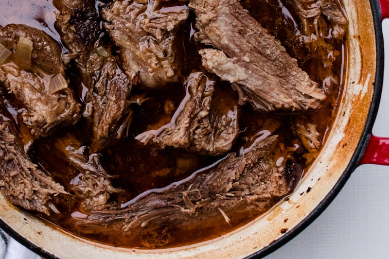 Brisket being braised in a slow cooker.