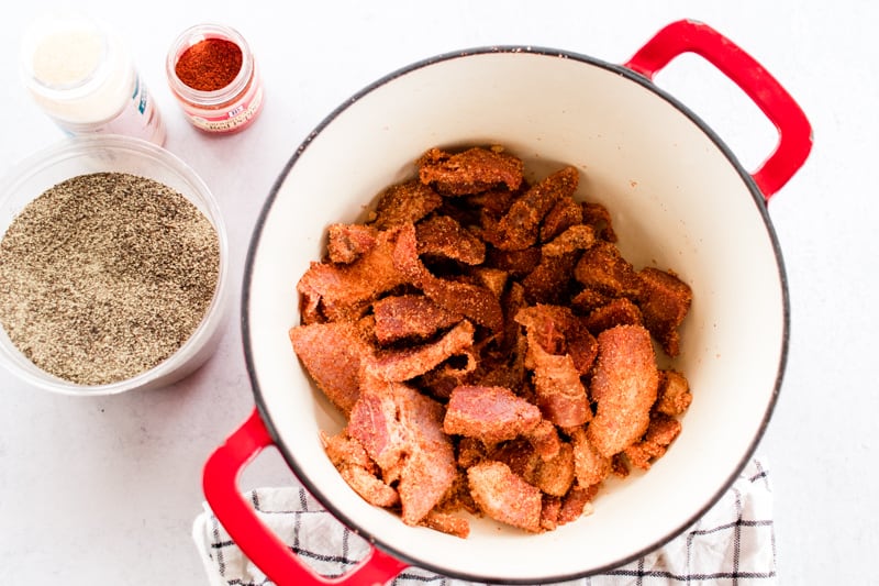 Pork belly burnt ends in a dutch oven with a dry rub.