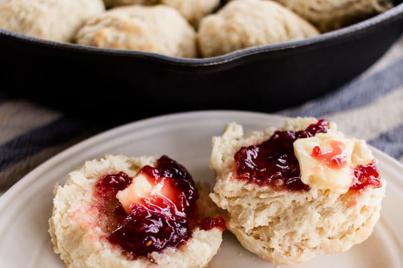 Homemade honey biscuits with butter and jam.