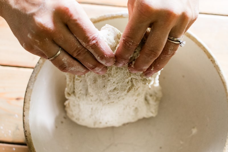 Stretching the bread dough out with my hands.