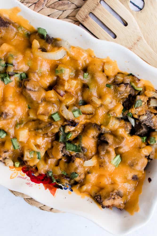 Garlic butter steak and potato skillet in a large casserole dish on a white marble countertop.