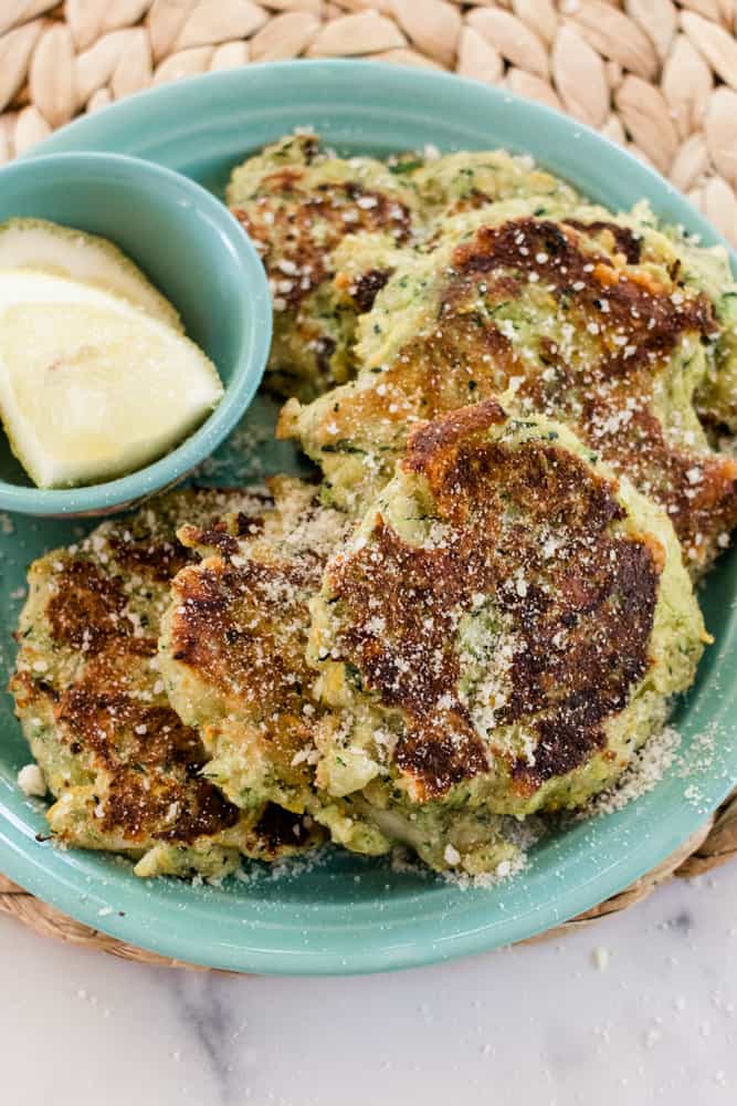 A plate of fried zucchini cakes with panko breadcrumbs.