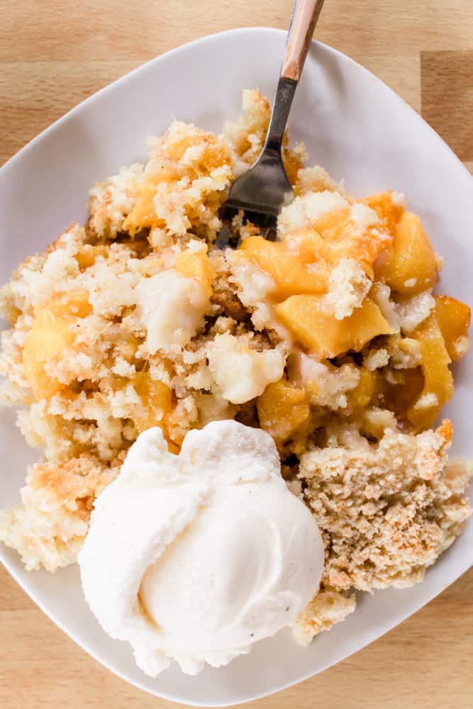 A plate of peach cobbler made from fresh peaches and a from scratch cobbler topping.