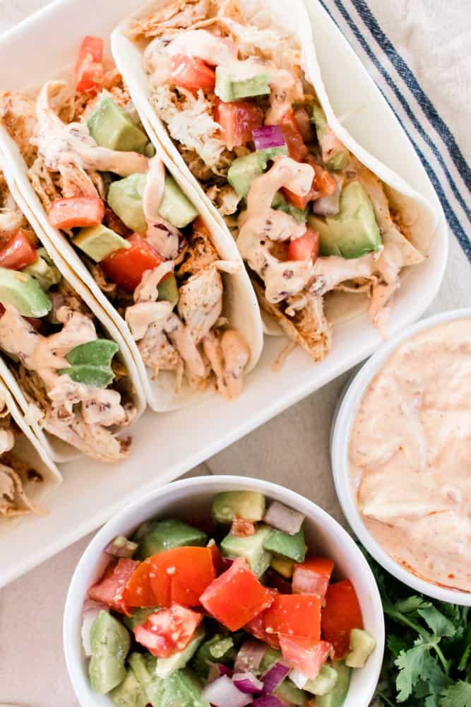 Shredded chicken street tacos with a bowl of pico and homemade chipotle sauce.