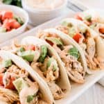 Shredded chicken street tacos with homemade chipotle sauce drizzled on top.
