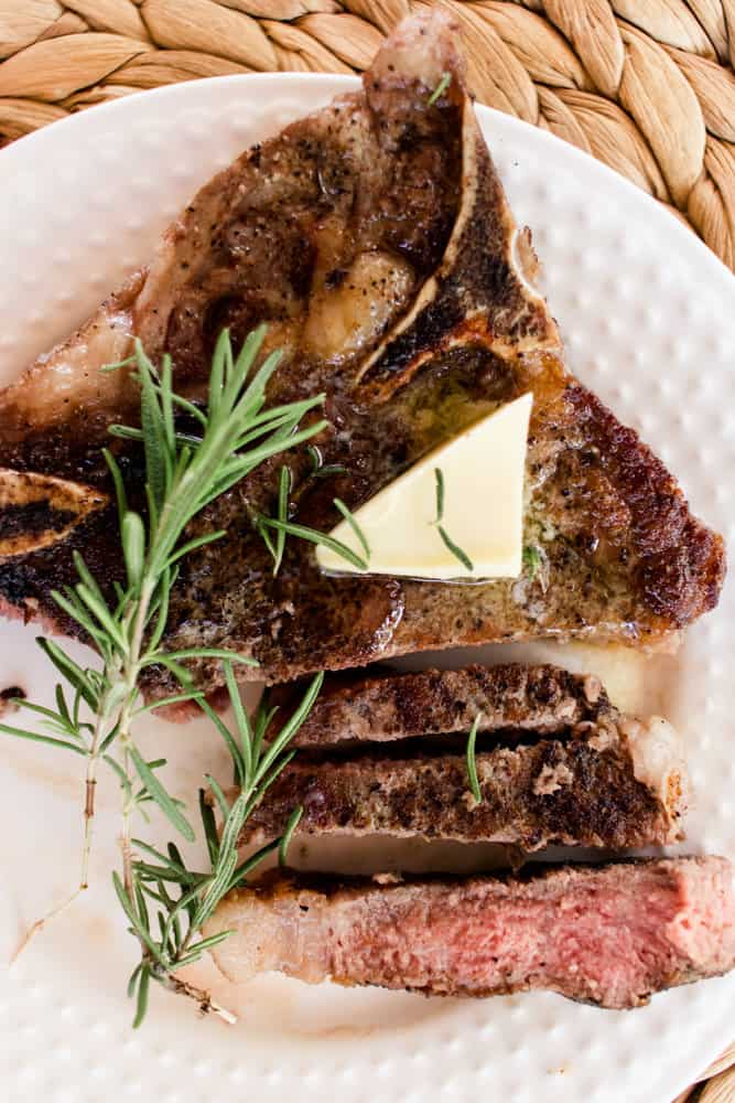 Butter melting on top of a tender t-bone steak after a reverse sear.