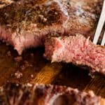 Tender reverse seared t bone steak on a fork.