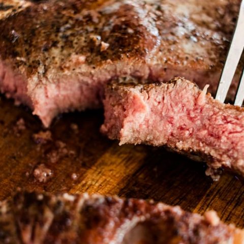 Tender reverse seared t bone steak on a fork.