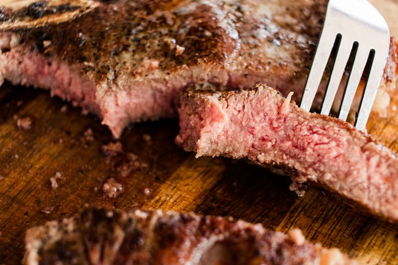 Tender reverse seared t bone steak on a fork.