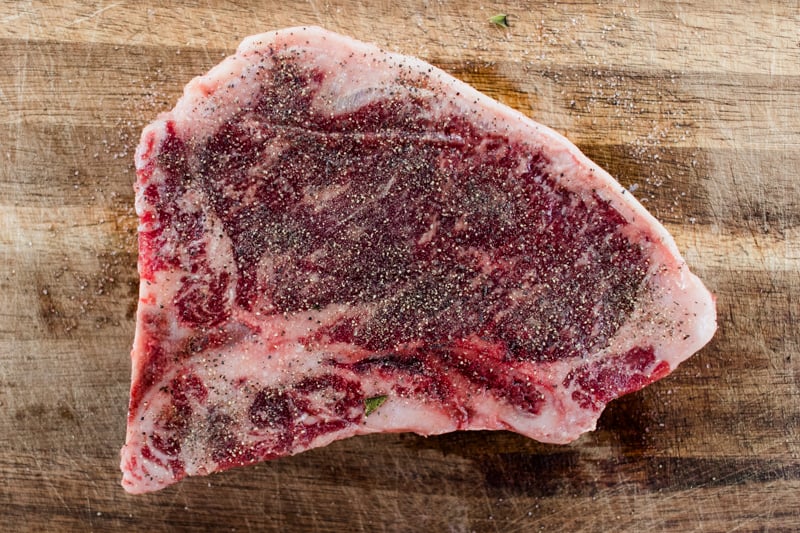 A large t bone steak coming to room temperature before cooking.