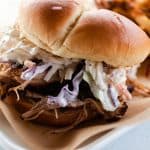 Dutch oven pulled pork sandwich with homemade slaw on a large bun.