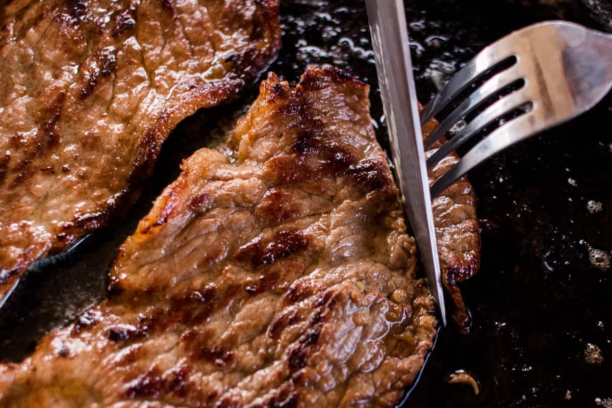 Cutting into a tender steak with a sharp knife.