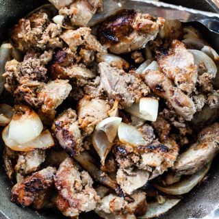 Chicken liver fried in a cast iron skillet with onions.