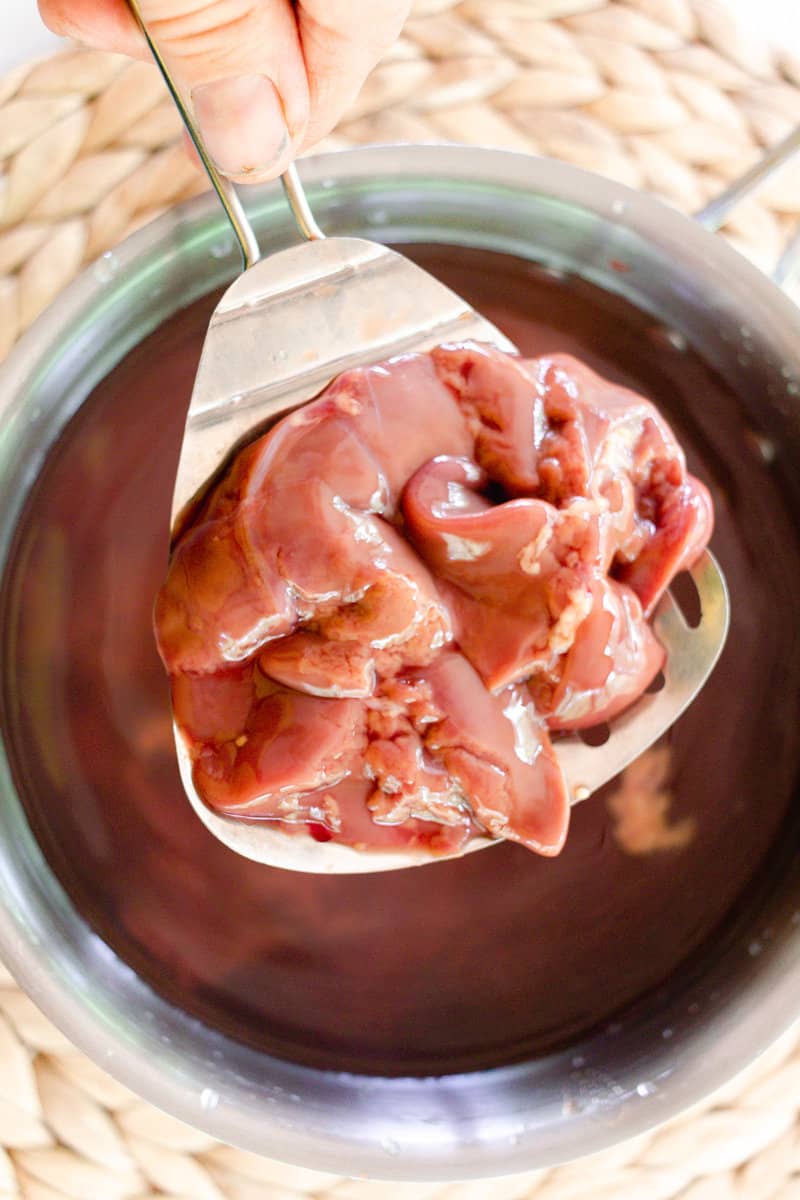 Setting the liver into a pot of boiling water.