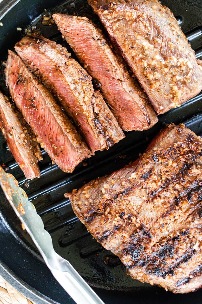 Cooking flat iron steaks on a grill top skillet.