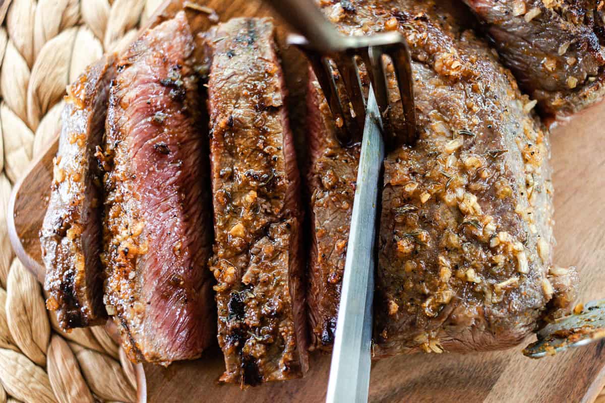 Slicing a flat iron steak with a sharp knife.