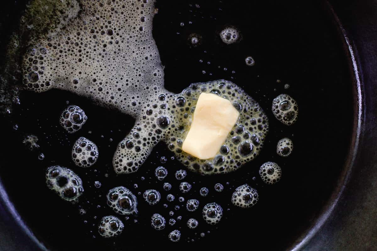 Butter melting in a sizzling cast iron skillet. 