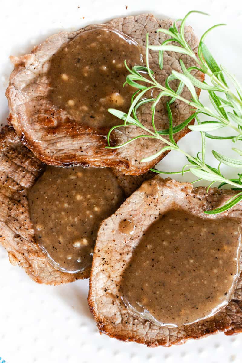 Eye of round steaks with a homemade gravy using white wine and a few sprigs of rosemary.