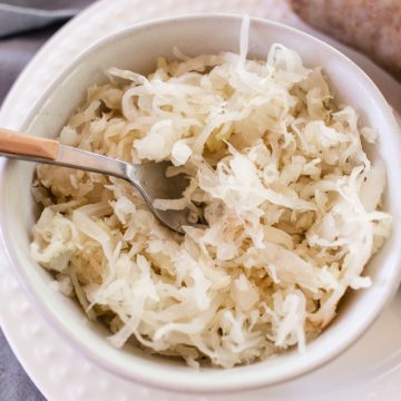 A bowl of fried sauerkraut with a spoon sticking out of it.