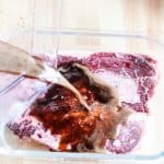 Submerging a venison steak in a homemade venison steak marinade.