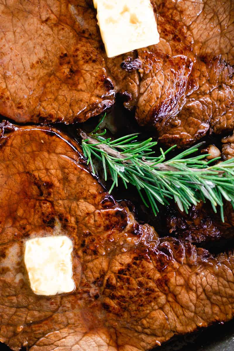 Venison steaks resting with a dollop of butter melting on top.