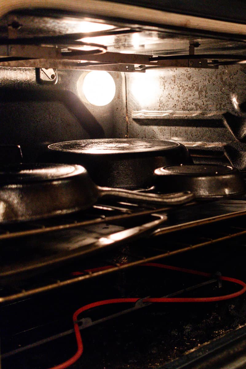 Cast iron skillets cooking in a oven with peanut oil.