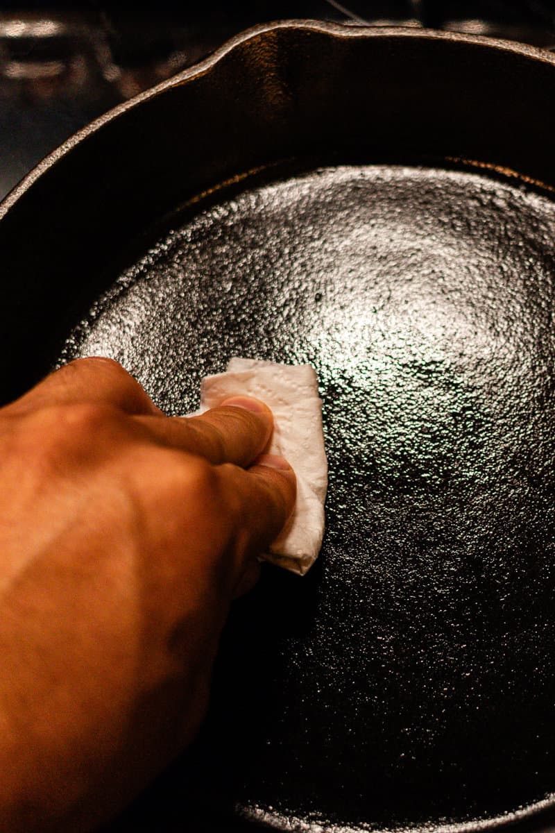 Wiping an old skillet with oil.