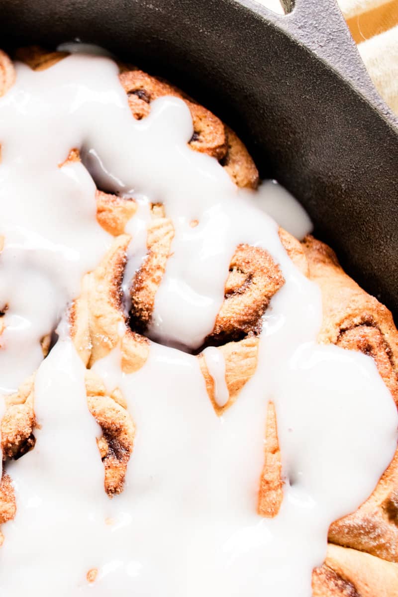 Cinnamon rolls made with protein powder resting in a cast iron skillet.